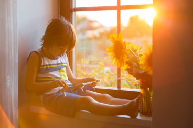 Abaküs ile bir pencere üzerinde günbatımı üzerinde oynayan sevimli küçük yürümeye başlayan çocuk