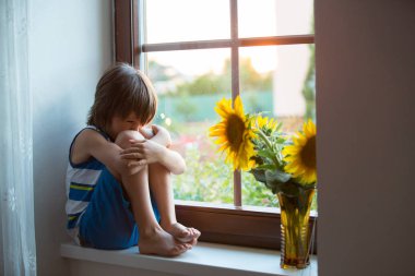 Abaküs ile bir pencere üzerinde günbatımı üzerinde oynayan küçük üzgün şirin yürümeye başlayan çocuk