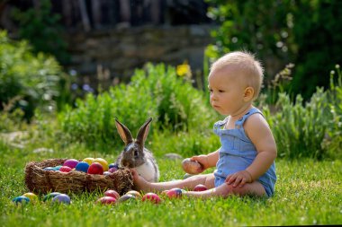 Çiçek Bahçe, ilkbaharda küçük tavşan ve Paskalya yumurta ile oynayan sevimli çocuk. Çocuk tavşan ile oynamak, tatil için avcılık yumurta
