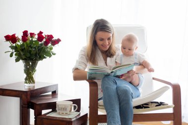 Anne, ona kitap okumak onun bebek çocuk sallanan sandalyede ile oynarken