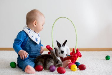 Bunnies ve evde, yumurta ile yumurta üzerinde renkli el çizimleri oynayan küçük yürümeye başlayan çocuk, bebek çocuk,