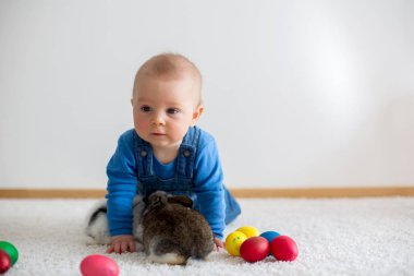 Bunnies ve evde, yumurta ile yumurta üzerinde renkli el çizimleri oynayan küçük yürümeye başlayan çocuk, bebek çocuk,