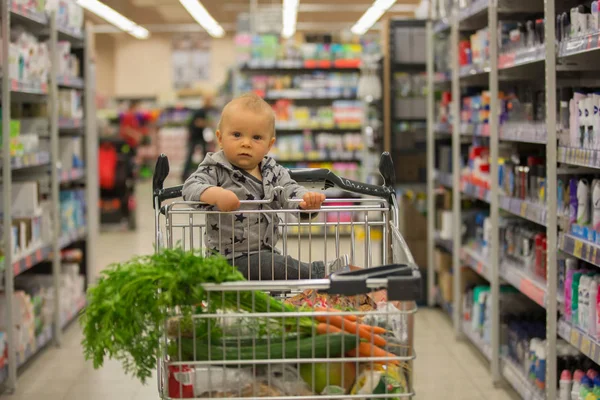Menino Bebê Sentado Carrinho Compras Mercearia Sorrindo Comendo Pão Enquanto — Fotografia de Stock