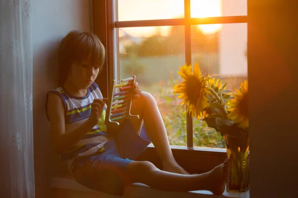 Niedliches Kleines Kleinkind Das Bei Sonnenuntergang Mit Abakus Fenster Spielt — Stockfoto
