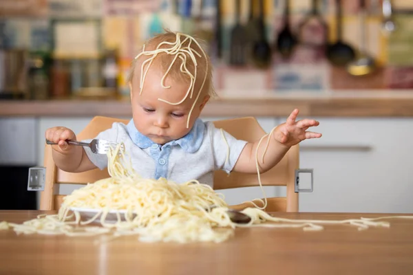 幼児子供用の小さな男の子 昼食にスパゲッティを食べるとキッチンの家に混乱を作って — ストック写真