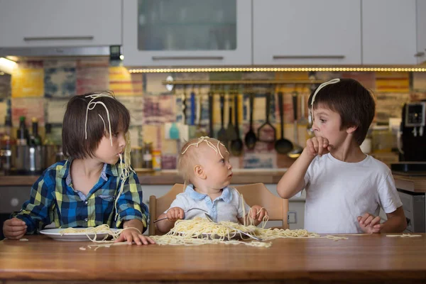 小さな男の子 幼児子供および彼のより古い兄弟 昼食にスパゲッティを食べるとキッチンの家に混乱を作って — ストック写真