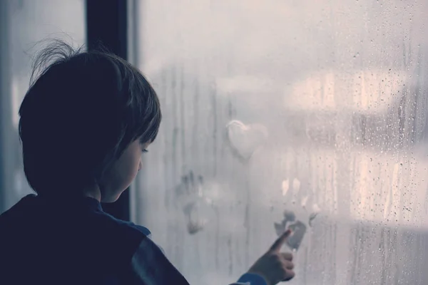 Niño Dejando Huellas Digitales Dibujando Corazones Una Ventana Casa — Foto de Stock