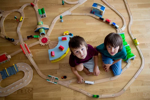 甜蜜的学龄前儿童 男孩兄弟玩木铁路和火车在家 顶视图 — 图库照片