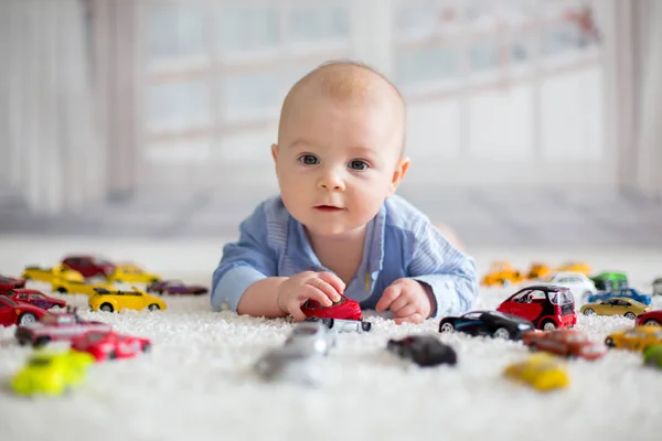 Förtjusande Baby Pojke Liggande Golvet Leksaksbilar Runt Honom Tittar Kameran — Stockfoto