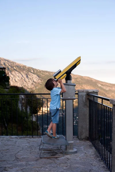 好奇的男孩 通过望远镜在有趣的事情 — 图库照片