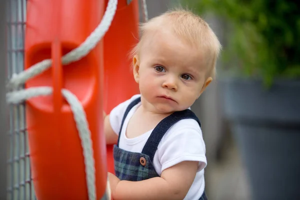 Милый Малыш Играющий Пластиковым Оранжевым Спасательным Поясом Ограды Парома — стоковое фото