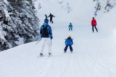 Baba ve oğul, okul öncesi çocuk, dağlarda, Avusturya Kayak merkezinde Kayak Kış