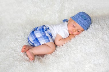 Şapkalı evde yatakta uyuyan sevimli bebek çocuk,