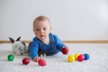 Bunnies ve evde, yumurta ile yumurta üzerinde renkli el çizimleri oynayan küçük yürümeye başlayan çocuk, bebek çocuk,