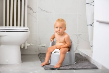 Lazımlık üzerinde oturan çocuk. Eğitici oyuncak ve tuvalet eğitimi kavramı ile oynayan çocuk çocuk. Öğrenen, geliştirme adımlar bebek