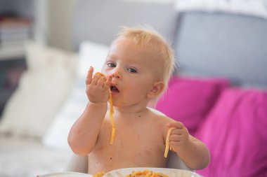 Küçük bebek bir yıl kapalı makarna yemek eski. Spagetti ile komik yürümeye başlayan çocuk. Sevimli ve sağlıklı gıda.