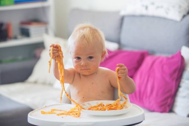 Küçük bebek bir yıl kapalı makarna yemek eski. Spagetti ile komik yürümeye başlayan çocuk. Sevimli ve sağlıklı gıda.
