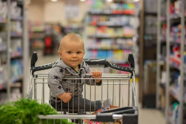 Menino Bebê Sentado Carrinho Compras Mercearia Sorrindo Comendo Pão Enquanto — Fotografia de Stock