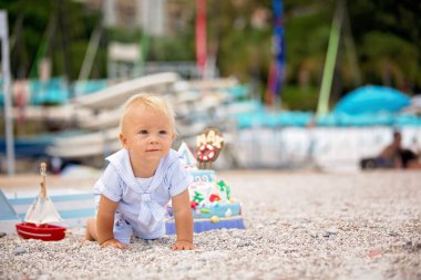 Tatlı bebek çocuk, Sahilde Deniz tema pasta ve deniz dekorasyon ile ilk Doğum günü kutluyor
