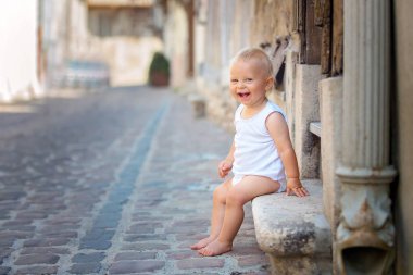 Tatlı bebek çocuk, vintage tarzı bir evde ne mutlu ki, gülümseyen şehrin eski bir kısmı ön verandaya oturup