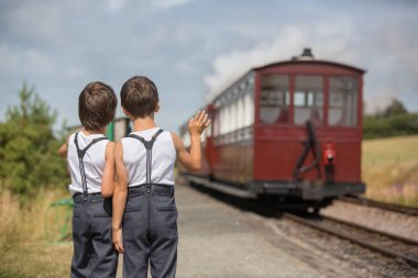 Güzel çocuk, giyinmiş vintage giysiler içinde eski buharlı tren sıcak yaz günlerinde İngiltere'de zevk.
