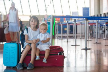 Çocuklar, birlikte seyahat ediyor, havaalanında uçağa binmek için bekliyor.