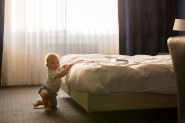 Güzel çocuk, Bebek Çocuk, ışığı güneşli yatak odası, geri yatakta oturup