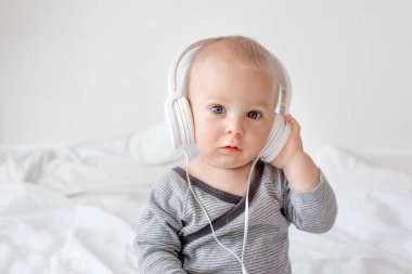 Sevimli küçük toddler bebek çocuk müzik dinleme yatakta baş telefonları ile