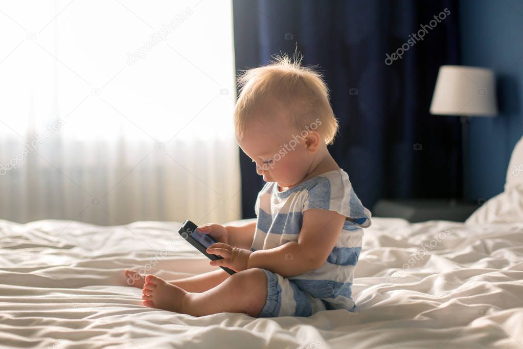 Beautiful baby boy, sweet child, lying in bed, playing in bed after bath, sleeping