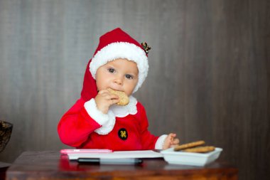 Tatlı yürümeye başlayan çocuk, çocuk, kurabiye yeme ve içme sütü evde, Noel babaya mektup yazma