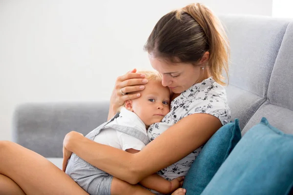Jovem Mãe Sentada Casa Sala Estar Ensolarada Abraçando Seu Bebê — Fotografia de Stock