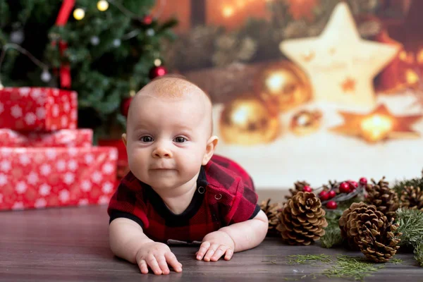圣诞节衣服的小男孩 躺在地板上 在他周围的圣诞装饰 — 图库照片