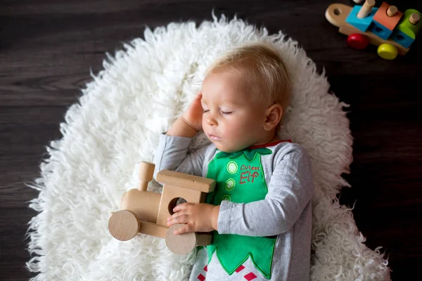 エルフ 彼の周りのクリスマスの装飾のような服を着て おもちゃのたくさんの眠っている少年 甘い幼児子供 — ストック写真