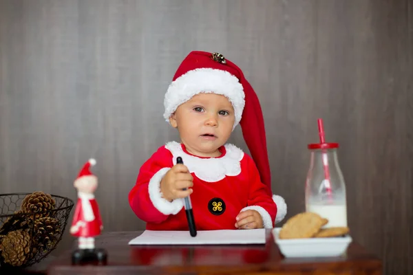 可爱的蹒跚学步的孩子 写信给圣诞老人在家里 吃饼干和喝牛奶 — 图库照片