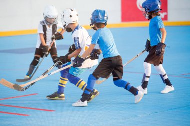 Team players having competitive hockey game outdoors clipart