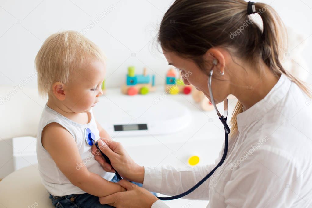 Pediatrician examining baby boy. Doctor using stethoscope to listen to kid and checking heart beat