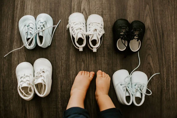 Kinderschuhe Und Babyfüße Auf Einem Holzhintergrund Isoliert — Stockfoto