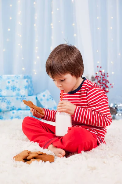 Roztomilý Šťastný Chlapeček Jíst Sušenky Pití Mléka Čekání Santa Pyžama — Stock fotografie