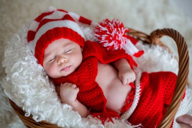 Tutmak oyuncak Santa şapka ve pantolon giyen küçük uyku yeni doğan oğlu,