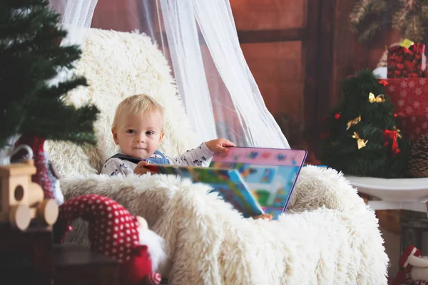 Netter Junge Liest Buch Auf Dem Stuhl Unter Dem Weihnachtsbaum — Stockfoto