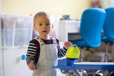 Tatlı yürümeye başlayan çocuk, oyuncak demir ve ütü masası, yardım Anne çamaşır ile oynamak