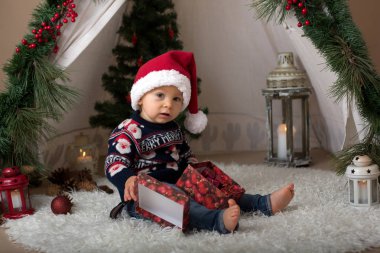 Çok güzel yürümeye başlayan çocuk, çocuk, onun Noel portre teepee, kardan adam ve diğer chirstmas dekorasyon dekore edilmiş oda çekilmiş olan festivly Noel ve santa şapka takmak için giyinmiş