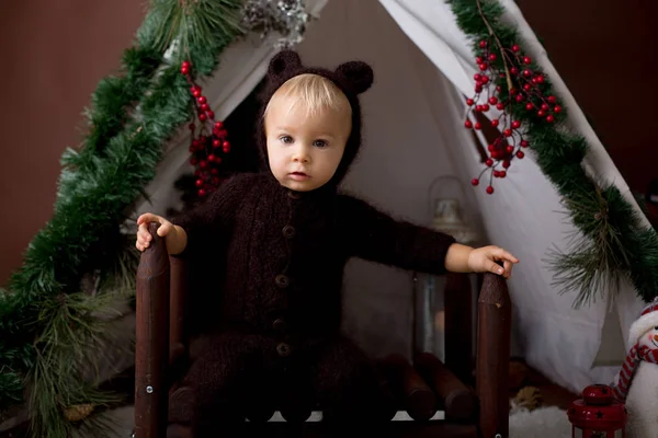 可爱的幼儿男婴在手工针织熊服装 在茶杯玩 装饰圣诞节 工作室拍摄棕色背景 — 图库照片