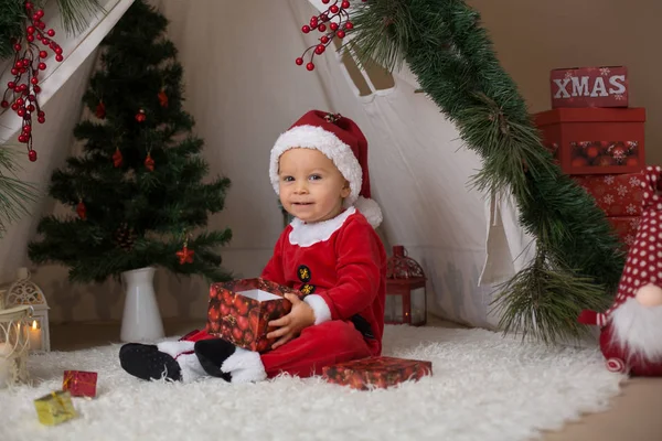 可爱的幼儿男婴身着圣诞老人服装 在家里玩装饰圣诞节的茶杯前 — 图库照片