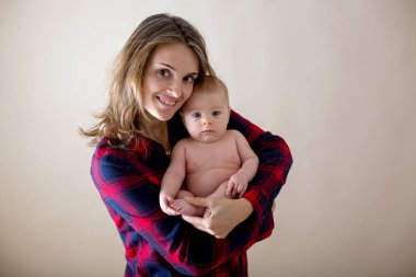 Onun yeni doğan bebek çocuk okşama, onun kollarında etrafında ve mutluluktan gülümseyen genç anne,