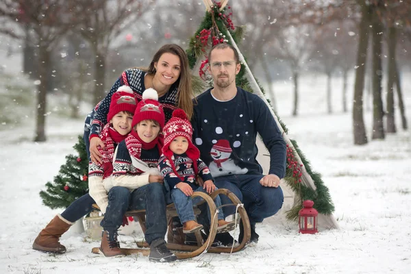 雪の中で楽しい屋外クリスマスを過ごし ティーピー クリスマスの装飾で遊んでいる子供たちと幸せな家族 — ストック写真