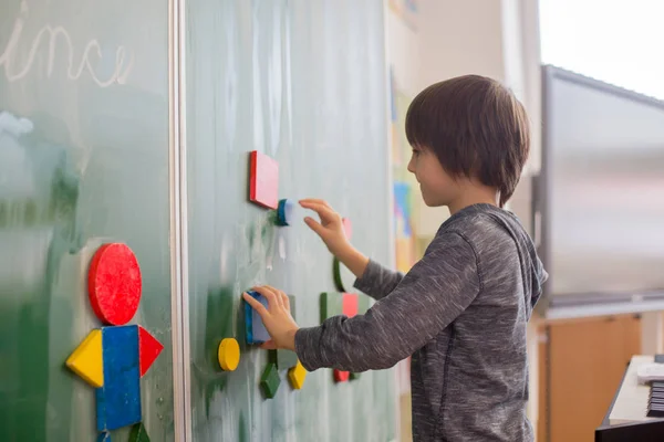 Birinci Sınıf Çocuğu Okulda Matematik Şekil Renkler Öğreniyor Karatahtanın Önünde — Stok fotoğraf