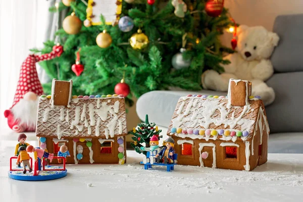 Two gingerbread houses, tree and people sitting on a bench, winter scene. Christmas concept