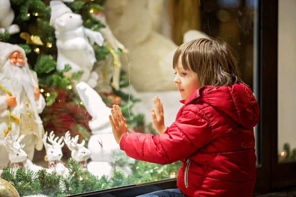 Mooi Klein Kind Jongen Kijken Naar Kerstdecoratie Met Speelgoed Etalage — Stockfoto