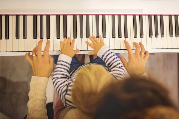 달콤한 긍정적인 어머니 피아노 어린이 집에서 — 스톡 사진